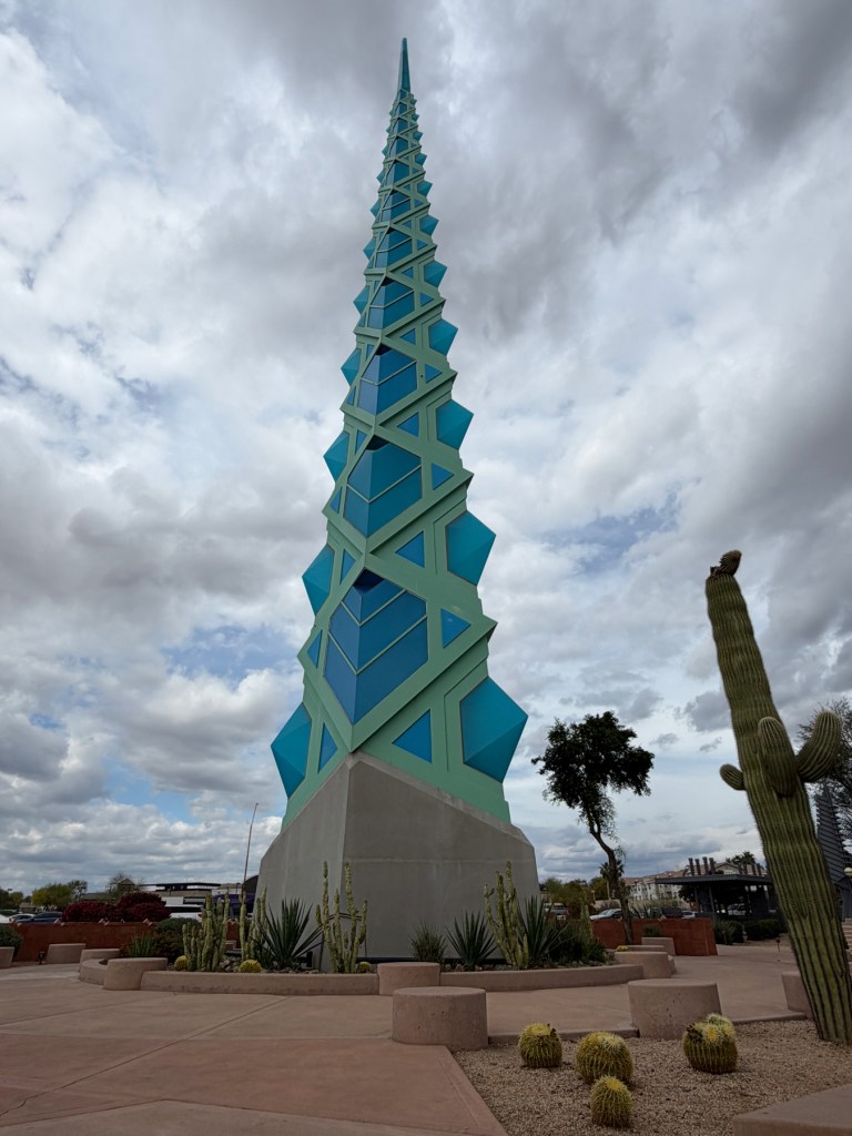 The base and lower section of the Frank Lloyd Wright spire, showing the angular architectural details, with desert cactus landscaping at its base, Frank Lloyd Wright Commemorative Park, Scottsdale, Arizona.