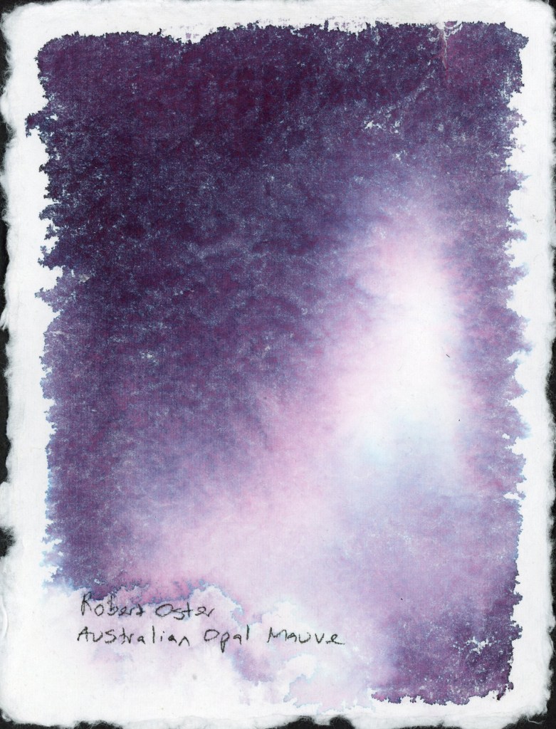 A full page chromatography study on handmade deckle-edge cotton watercolor paper. Robert Oster Australian Opal Mauve floods the page in deep violet and plum tones, with a luminous soft pink and white centre where the ink has separated and travelled outward. The fibrous texture of the handmade paper creates a dramatic, organic surface.