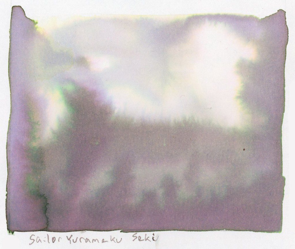 A large soft ink wash swatch on white sketchbook paper, labeled Sailor Yurameku Seki in the artist's handwriting below. The wash is a delicate ethereal grey-purple with soft pink undertones, blooming and pooling gently across the page in an irregular rectangular shape with slightly ragged edges. Stillman and Birn Alpha sketchbook.
